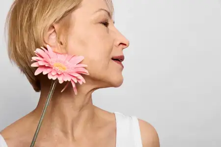Крупный план женщины с розовым цветком