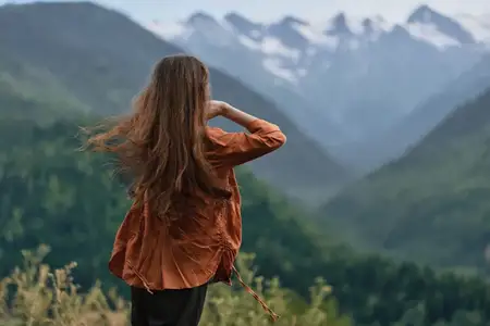 Женщина, любующаяся горным пейзажем на открытом воздухе