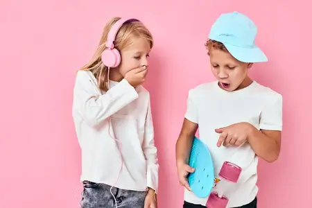 Стильные юные друзья со скейтбордом и наушниками играют в студии