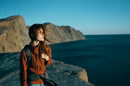 Симпатичная женщина-туристка с рюкзаком наслаждается свежим воздухом, свободой и приключениями