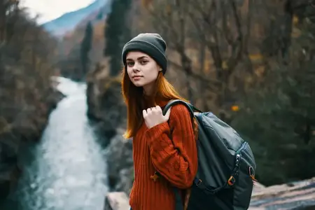 Турист с рюкзаком в лесу на фоне природы, гор и реки во время путешествия