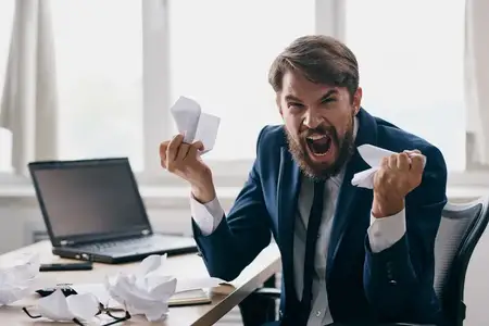 Бизнесмены работают за ноутбуком в офисе, испытывая эмоции недовольства от технологий