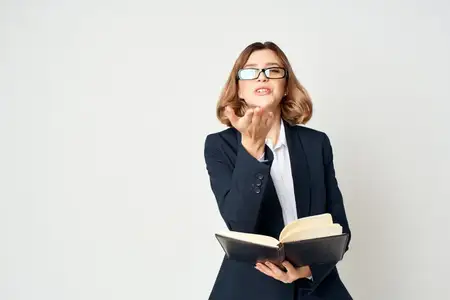 Деловая женщина в костюме с блокнотом в руках документирует работу в студийном офисе