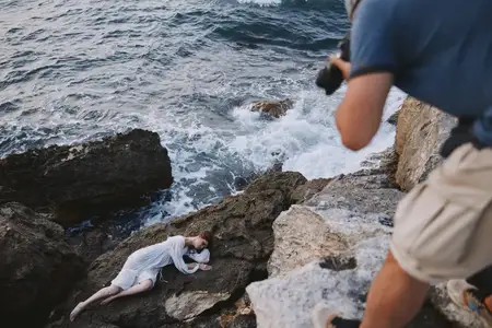 Женщина лежит на камне у моря на фоне природного ландшафта