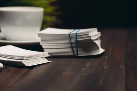 Визитные карточки, настольная ручка, офисные принадлежности и фирменный бланк на деревянном столе