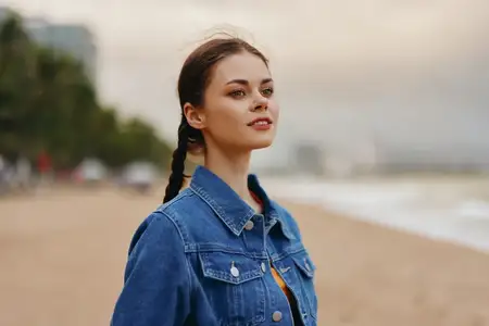 Счастливая молодая женщина, портрет симпатичной улыбающейся модели, наслаждающейся беззаботным летним отпуском на пляже, в объятиях природы и свободы на фоне спокойного океана на закате