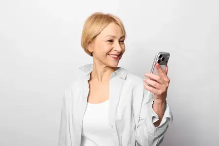 Женщина улыбается, держа смартфон