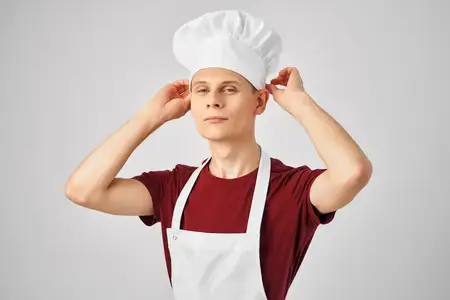 Мужчина в фартуке профессионально работает на кухне
