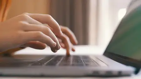 Крупный план: человек печатает на клавиатуре ноутбука, работая в интернете и общаясь
