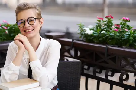 Девушка отдыхает в летнем кафе на открытом воздухе, весело прогуливаясь по городу