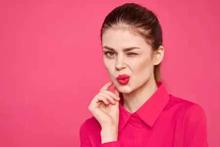 Привлекательная девушка в розовой рубашке, обрезанный вид, яркий макияж, красные губы, жестикулирует руками