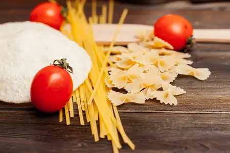 Ингредиенты для итальянской пасты на деревянном столе на кухне