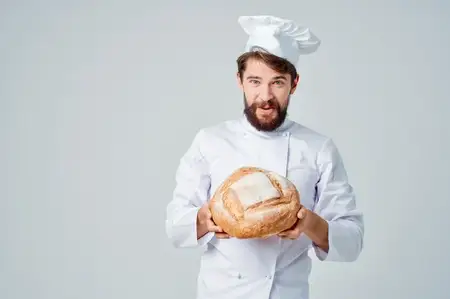 Повар-мужчина на кухне, занимающийся выпечкой
