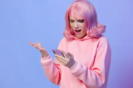 Портрет женщины, которая улыбается и пользуется смартфоном, кадр обрезан