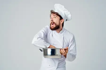 Эмоциональный повар-мужчина с кастрюлей в руках, работа на кухне, ресторанная индустрия
