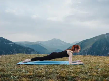 Спортивная женщина занимается йогой и медитацией в горах на открытом воздухе