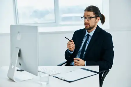 Офисный работник за столом в очках, работа с технологиями