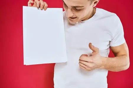 Эмоциональный мужчина держит лист бумаги