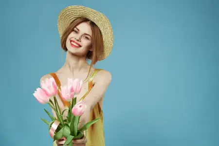 Улыбающиеся женщины с букетом цветов в шляпке на весенний праздник