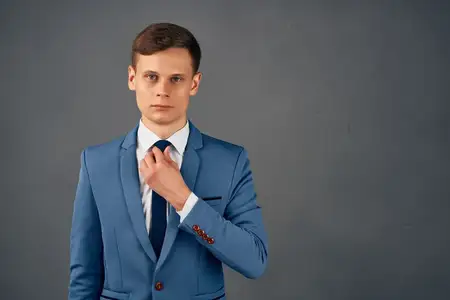 Менеджер в костюме поправляет галстук, предприниматель в офисе, профессиональная работа