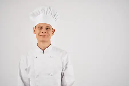 Весёлый шеф-повар-мужчина работает на кухне ресторана
