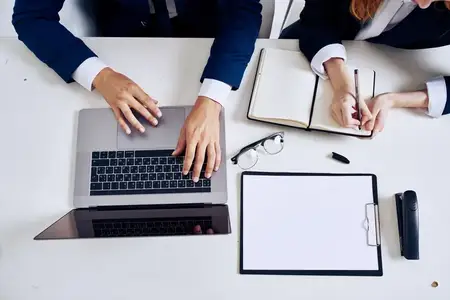 Менеджеры работают в команде в офисе с ноутбуками, официальные лица