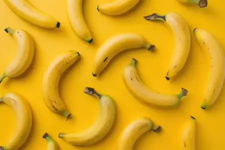 Спелые бананы на ярком желтом фоне, плоская раскладка свежих фруктов
