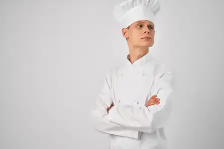 Мужчина в поварской форме позирует, демонстрируя профессионализм в работе