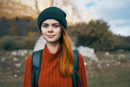 Женщина-туристка наслаждается природой во время путешествия и отдыха на лоне природы, вокруг царит веселая атмосфера