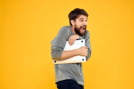 Мужчина с ноутбуком, беспроводные технологии, интернет, стиль жизни, работа, желтый изолированный фон
