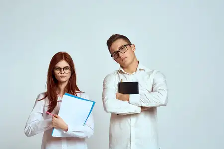 Бизнесмен и женщина-секретарь с документами, сотрудники, коллеги на светлом фоне, кадр обрезан