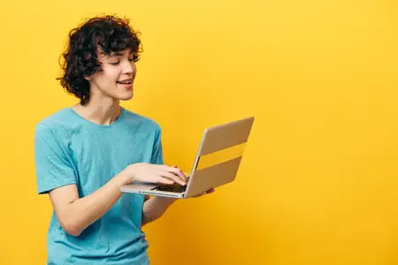 Мужчина в синей футболке с ноутбуком на желтом фоне, интернет