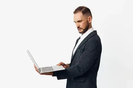 Изображение запечатлело делового профессионала за работой: сосредоточенного и собранного, он взаимодействует с цифровым устройством на однотонном цветном фоне, что подчеркивает его опыт и решимость