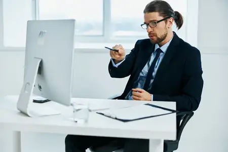 Мужчина в костюме, официальное лицо, работает за компьютером