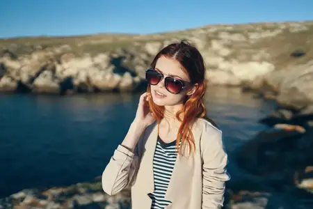 Счастливая путешественница играет в футбол у моря в горах
