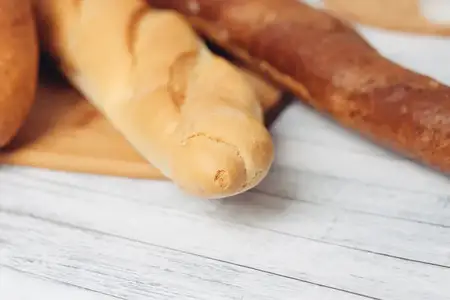 Свежеиспеченные буханки хлеба в хлебнице на кухне