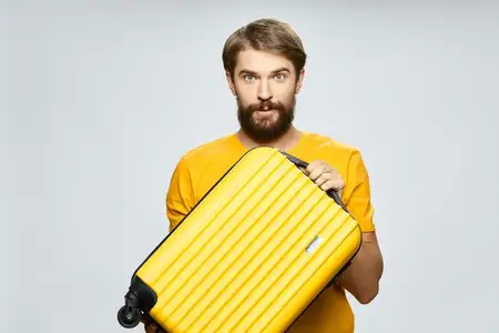 Бородатый мужчина на жёлтом чемодане, отдых, путешествие