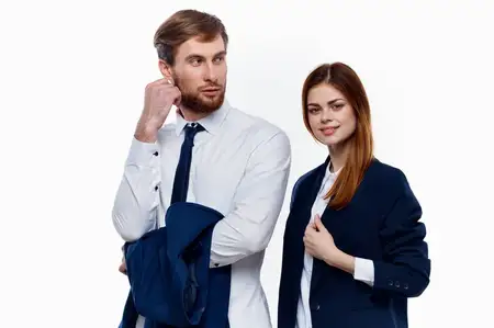 Мужчина и женщина в костюмах стоят рядом с коллегами по работе в финансовом офисе на светлом фоне
