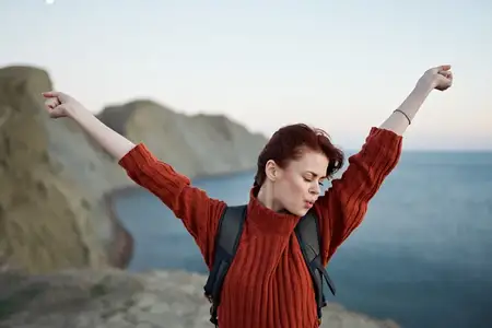 Путешествие с поднятыми вверх руками в горах у моря на природе