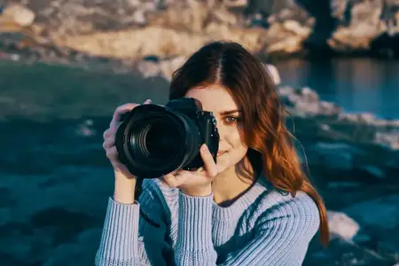 Женщина-фотограф на фоне скалистых гор, путешествие, отпуск, свежий воздух
