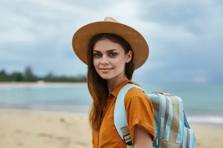 Женщины-туристки в шляпе с рюкзаком на фоне островного пейзажа