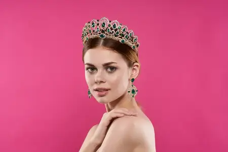 Красивая женщина с обнаженными плечами, украшения, косметика, позирует на изолированном фоне