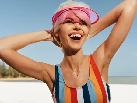 Яркое настроение беззаботного летнего веселья, уверенная поза, теплый свет, игривая энергия, ветерок на открытом воздухе, расслабленная атмосфера, морской горизонт, яркие цвета, радостное выражение…