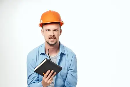 Мужчина в оранжевой защитной каске, работающий по профессии