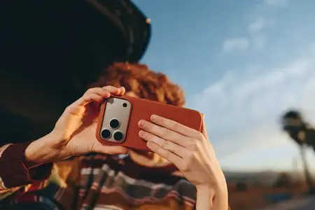 Женщина на улице делает селфи на смартфон, руки обрамляют портрет