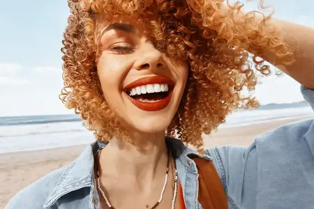 Улыбающаяся женщина на пляже с рюкзаком наслаждается счастливым отпуском: «Портрет молодой модели на фоне природы»