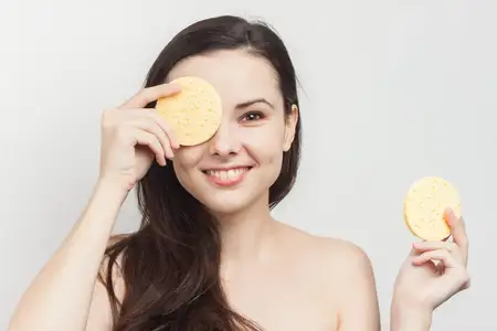 Веселая брюнетка с обнаженными плечами, чистая кожа лица, крупным планом