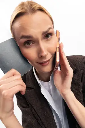 Обеспокоенная женщина держит паспорт и смартфон близко к лицу