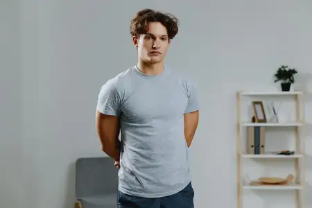 Спортивный мужчина занимается фитнесом дома, используя ноутбук для онлайн-тренировок