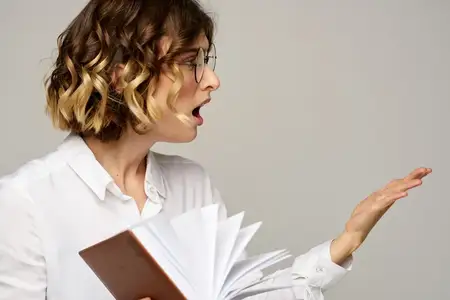 Женщина с блокнотом в руках занимается бизнесом на бежевом фоне